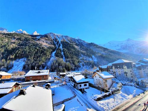 a town in the snow with a mountain in the background at Grand Studio Aiguille du Midi et vue Mont Blanc in Chamonix-Mont-Blanc
