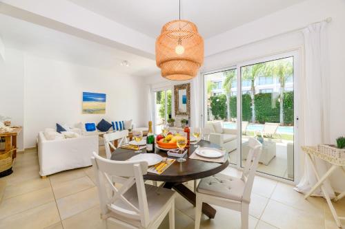 una sala da pranzo e un soggiorno con tavolo e sedie di Villa Atlantis a Protaras