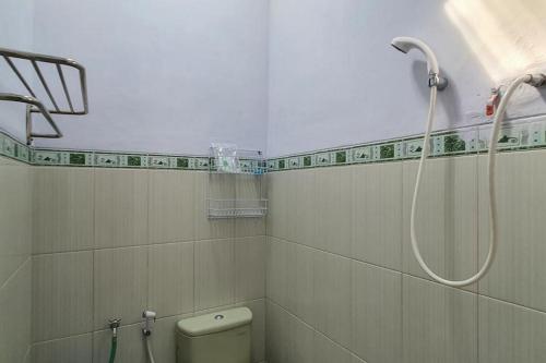 a bathroom with a shower and a toilet at Angrumba Family Homestay near RSUD Caruban Mitra RedDoorz in Mejayan
