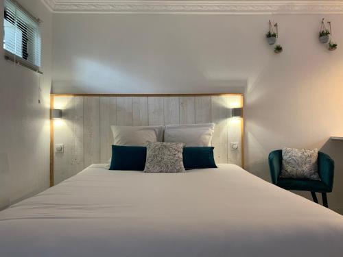 a bedroom with a large white bed and a chair at Abatilles in Arcachon