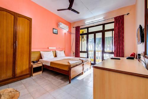 a bedroom with a bed with orange walls at Colva Residency in Colva