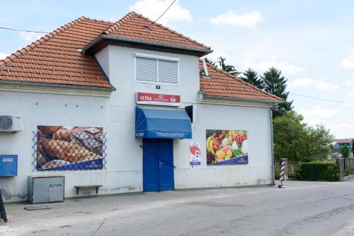 a small white building with a blue door at Apartment Mia in Donja Pačetina