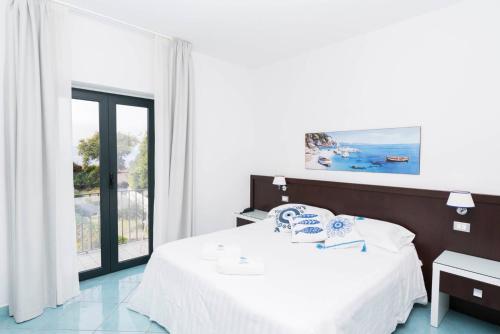 a bedroom with a bed and a large window at Hotel Murmann in Maratea