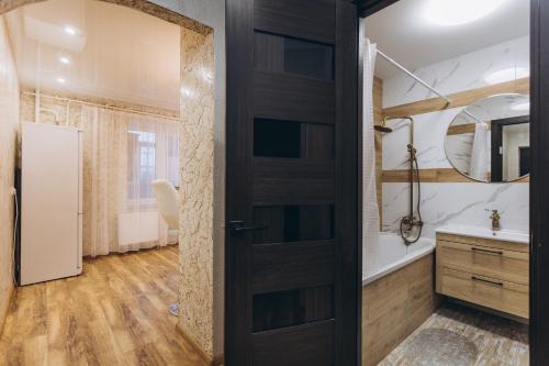 a bathroom with a black door and a sink at LUXE Apartments Illinskaya 3 floor in Sumy