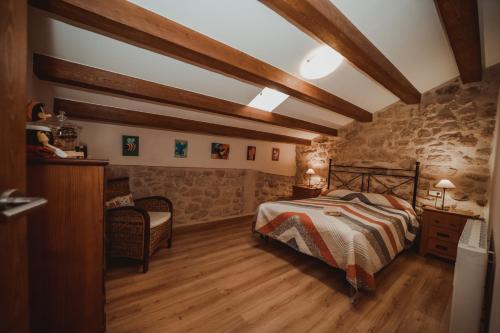 - une chambre avec un lit et un mur en pierre dans l'établissement Ca La Leonor, Ecoturisme Terra Alta, à Bot