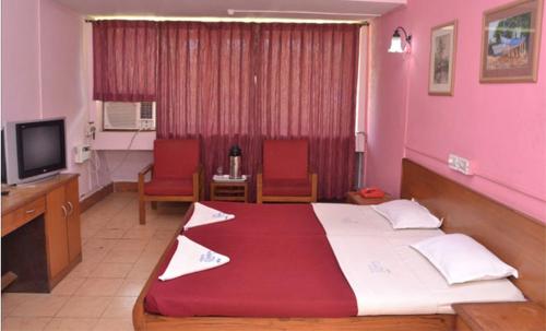 a bedroom with a large bed in a pink room at Colva Residency in Colva