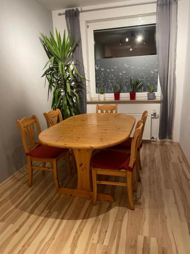 una mesa de madera y sillas en una habitación con ventana en Apartment 22, en Kirchhain