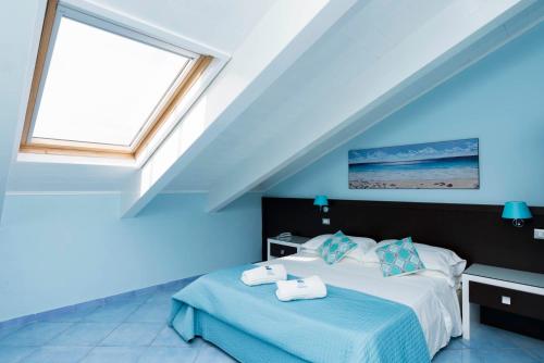 a blue bedroom with a bed and a window at Hotel Murmann in Maratea