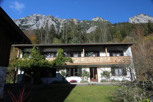 a house with a balcony with mountains in the background at Ferienwohnungen Reiteralpe in Ramsau