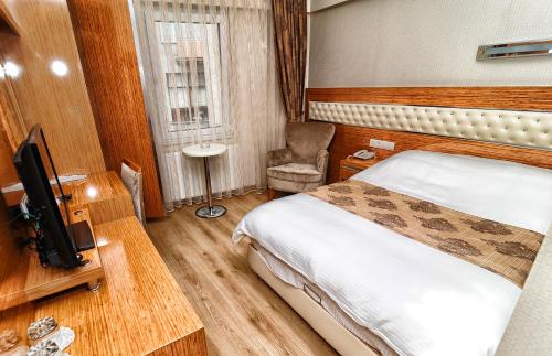una camera d'albergo con letto e TV di Serenti Pamuk Hotel a Giresun
