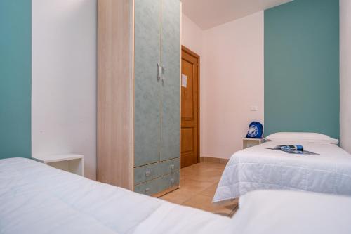 a bedroom with two beds and a cabinet in it at Club del Sole Stork Family Collection in Giulianova