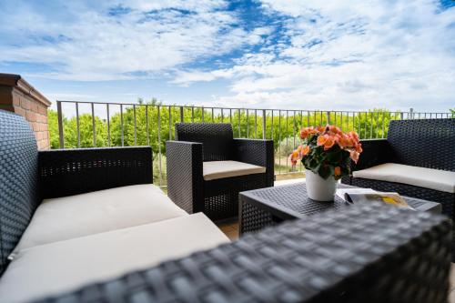 a patio with chairs and a table with a vase of flowers at Club del Sole Stork Family Collection in Giulianova