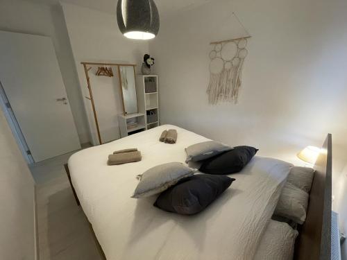 een slaapkamer met een groot bed met kussens bij Le Relax by La Dame de Coeur - Logement zen urbain in Namen