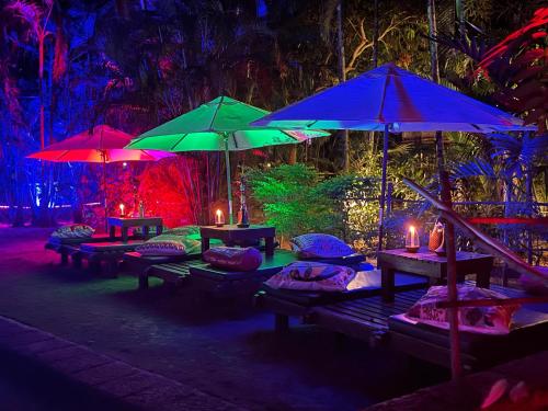 a group of picnic tables with umbrellas at night at Presa di Goa - Managed by Smith and Appy in Calangute