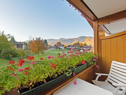 a balcony with flowers and a view of a yard at Landhotel Gabriele in Unterwössen