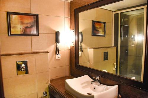 Aaron Residency في نيودلهي: حمام مع حوض ومرآة