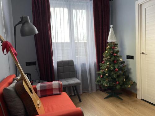 uma sala de estar com uma árvore de Natal e um sofá em Petrov Avenue Guest House em Pereslavl-Zalessky