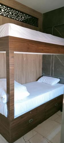 a wooden bunk bed with white pillows on it at Hotel Florence in Nānded