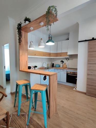 a kitchen with blue stools and a counter in a room at Largo A2 in Alcácer do Sal