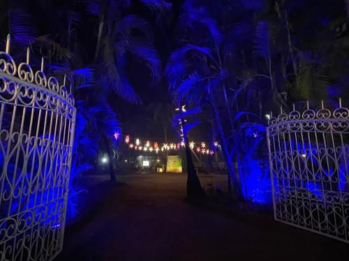 a gate at night with palm trees and lights at Presa di Goa - Managed by Smith and Appy in Calangute