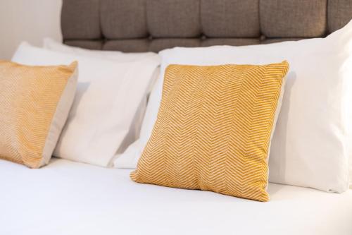 a group of pillows sitting on top of a bed at 5BRM - Off Road Parking - 3 Bath - Garden in Swansea