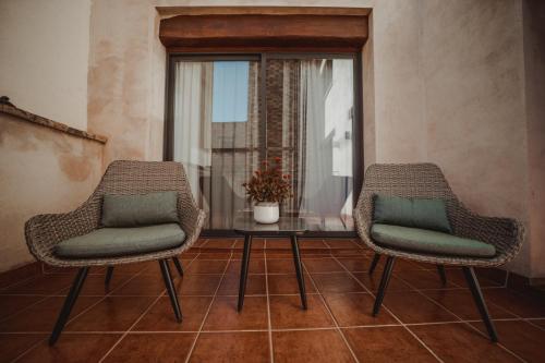 two chairs and a table in a room with a window at Cal Tomas, Ecoturisme Terra Alta in Bot