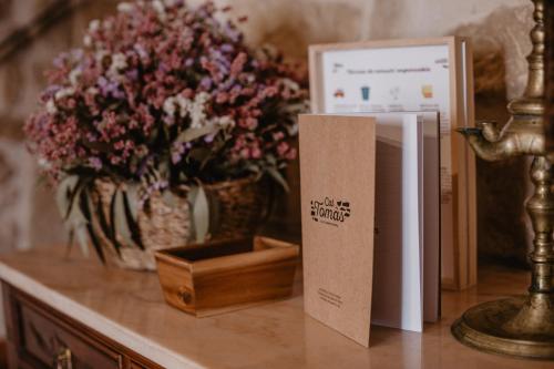 a table with a vase of flowers and a box on it at Cal Tomas, Ecoturisme Terra Alta in Bot