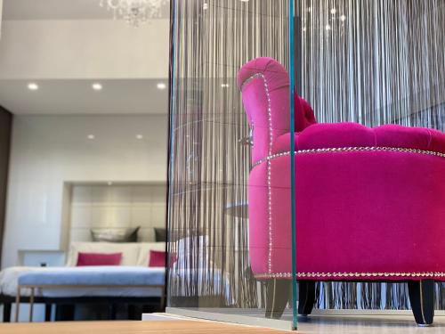 a pink chair in a glass case in a room at Gran Paradiso Hotel Spa in San Giovanni Rotondo