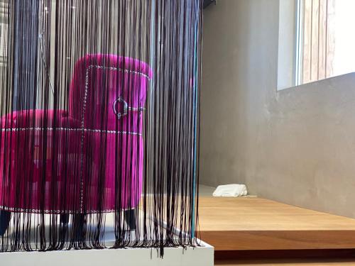 a pink chair sitting in front of a bed at Gran Paradiso Hotel Spa in San Giovanni Rotondo