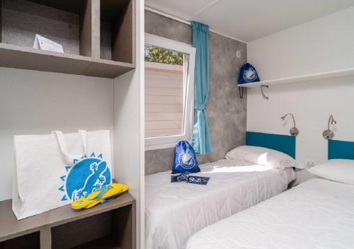 two beds in a room with blue and white at Club del Sole Stork Family Collection in Giulianova