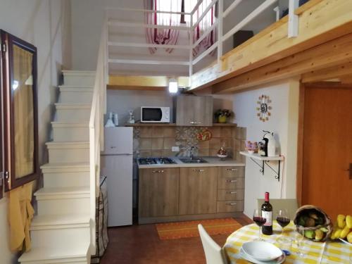 une cuisine avec une table et une cuisine avec un escalier dans l'établissement La casa di Anita nel cuore di Segesta, à Calatafimi-Segesta