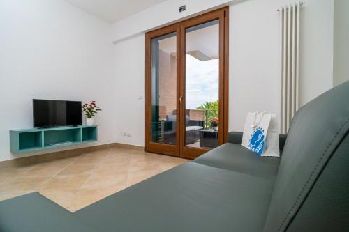 a living room with a couch and a television at Club del Sole Stork Family Collection in Giulianova