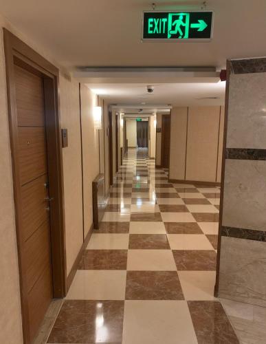 a hallway in a building with a checkerboard floor at Olive Tree Amman in Amman