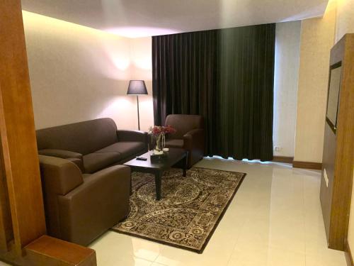 a living room with a couch and a table at Olive Tree Amman in Amman