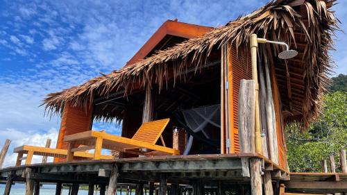 a resort with two chairs and a thatched roof at Nyande Raja Ampat in Pulau Mansuar