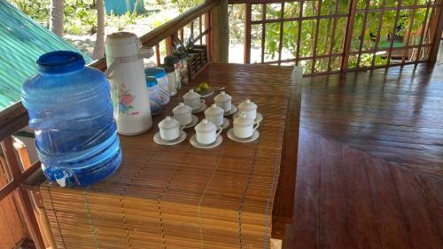 a large bottle of water sitting on a wooden table with a chess at Nyande Raja Ampat in Pulau Mansuar