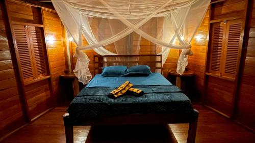 a bedroom with a bed with a canopy at Nyande Raja Ampat in Pulau Mansuar