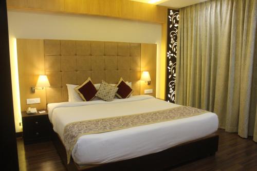 a bedroom with a large bed in a hotel room at Ramada by Wyndham Varanasi Katesar in Chandauli