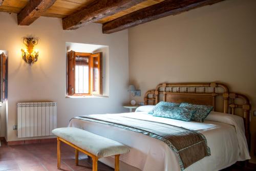 een slaapkamer met een groot bed en een stoel bij CASA RURAL LAS BODEGAS in Valbuena de Duero