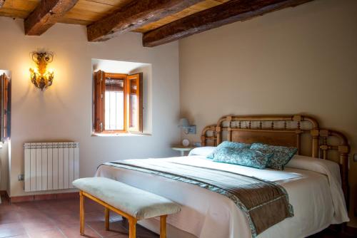 a bedroom with a large bed and a chair at CASA RURAL LAS BODEGAS in Valbuena de Duero