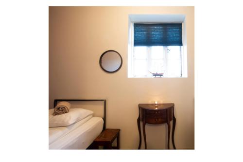 a bedroom with a bed and a table and a window at Sjávarborg in Stykkishólmur