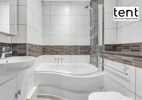 a white bathroom with a tub and a sink at Stylish & Comfy 1 Bed Apt by Tent Serviced Apartments Egham - Town centre with parking and Wifi in Egham
