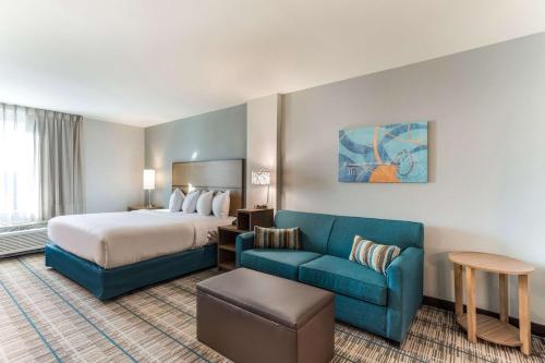 Habitación de hotel con cama y sofá azul en MainStay Suites Murfreesboro, en Murfreesboro
