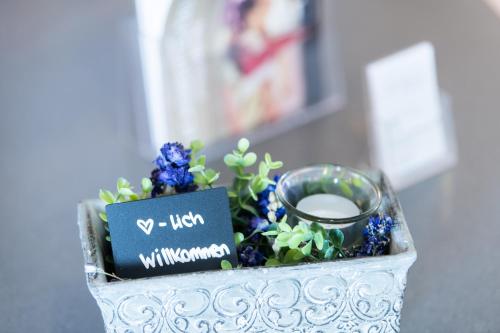 a container with blue flowers and a ring in it at La Tgoma - Hotel & Restaurant in Lenz