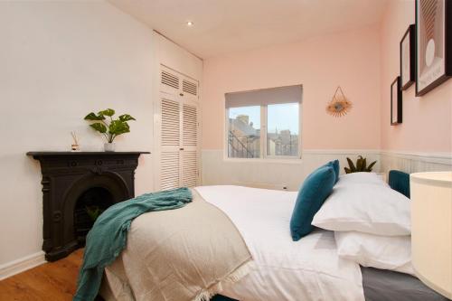 ハロゲートにあるCentral Harrogate 2 Bedroom Apartmentのベッドルーム(白いベッド1台、暖炉付)