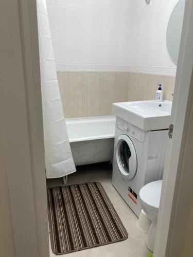 a bathroom with a washing machine and a washer at City Center Studio Appartment Центр города, автовокзал, двухкомнатная квартира Петра Дорошенка 4 in Kryvyi Rih