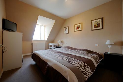 a bedroom with a bed and a window at Le Relais du Morvan in Vézelay