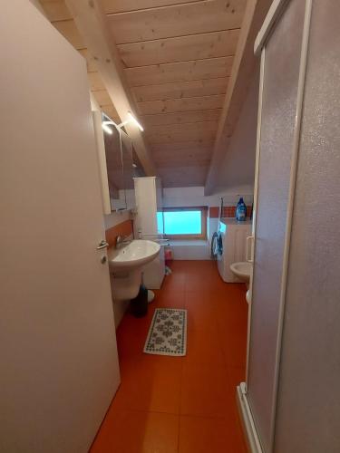 a bathroom with a sink and a toilet and a mirror at Appartamento Al Borgo in Cles