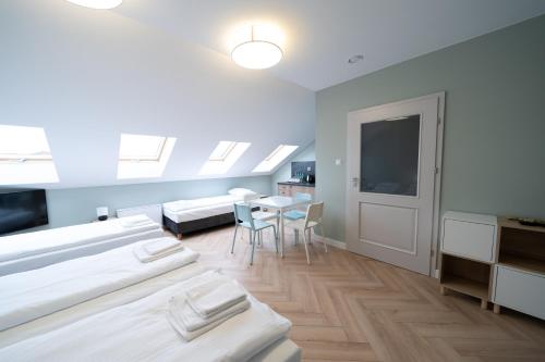 a room with four beds and a table with chairs at Pensjonat Dominikański in Krasnobród