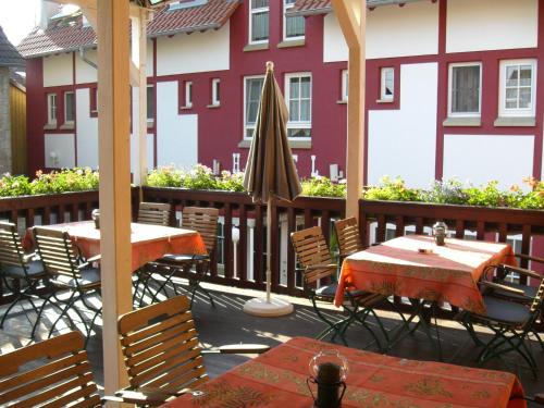 a patio with tables and chairs and a umbrella at Cross-Country-Hotel Hirsch in Sinsheim